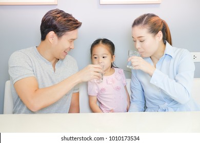 Asian Family Drinking Water With Together