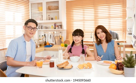 Asian Family Enjoy Eating Breakfast Together In Kitchen Room At Home.