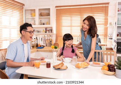 Asian Family Enjoy Eating Breakfast Together In Kitchen Room At Home.