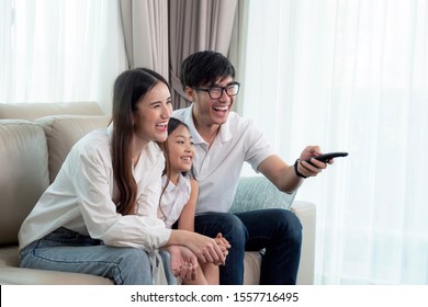 Asian family enjoy looking lcd tv on sofa in living room, this image can use for home, television, house, father, mother and watching concept