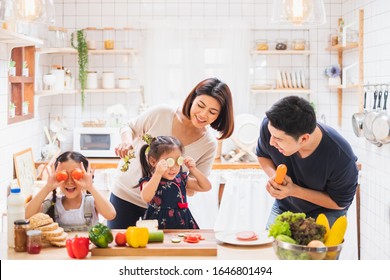 Asian Family Enjoy Playing And Cooking Food In Kitchen At Home