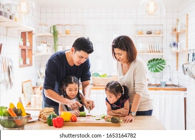 Asian Family Enjoy Playing And Cooking Food In Kitchen At Home