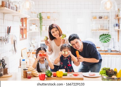 Asian Family Enjoy Playing And Cooking Food In Kitchen At Home