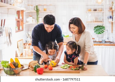 Asian Family Enjoy Playing And Cooking Food In Kitchen At Home