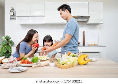 Asian Family Enjoy Playing And Cooking Food In Kitchen At Home