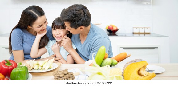 Asian Family Enjoy Playing And Cooking Food In Kitchen At Home