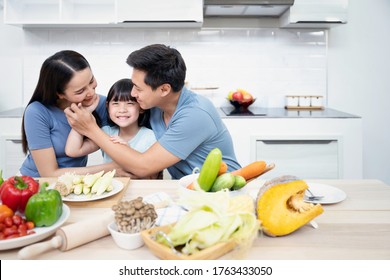 Asian Family Enjoy Playing And Cooking Food In Kitchen At Home