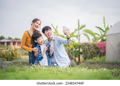 Asian family enjoy with taking selfie in garden, mom, dad and son relationship, happy family travelling together concept. - Powered by Shutterstock