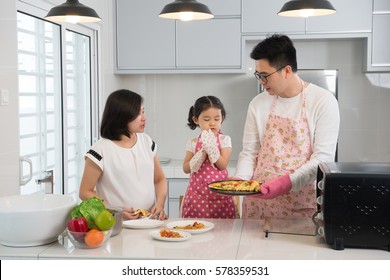 Asian Family Enjoying And Cooking Pizza