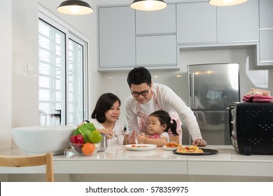 Asian Family Enjoying And Cooking Pizza