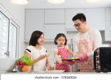 Asian Family Enjoying And Cooking Pizza