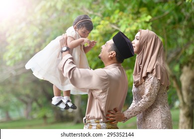 Asian Family Enjoying Quality Time With Father, Mother And Daughter In Park