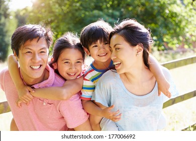 Asian Family Enjoying Walk In Summer Countryside