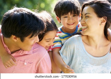 Asian Family Enjoying Walk In Summer Countryside