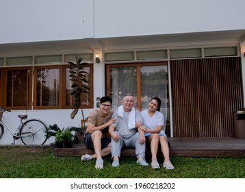 Asian Family Exercising Together At Home. Senior Father With Adult Daughter And Son Enjoy Workout Together In The Garden. Retirement Elderly Male With Son Spending Time Together With Weekend Activity.