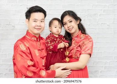 Asian Family, Father, Mother And Baby In Red Clothes Celebrating Chinese New Year