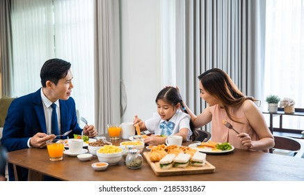 Asian family father, mother with children daughter eating healthy breakfast food on dining table kitchen in mornings together at home before father left for work, happy couple adult family concept - Powered by Shutterstock