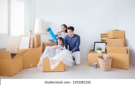 Asian Family Father Mother Daughter Packing Cardboard Box Move To New House, Online Marketing E-commerce Unpack Stuff Belongings Home Delivery. Lifestyle Happy Asian Family Together Relocation Concept