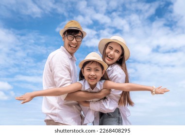 Asian family father, mother and daughter playing togather in fly action with beach and summer background in holiday time - Powered by Shutterstock