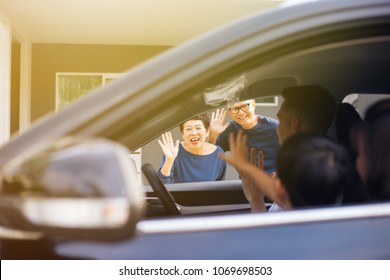 Asian Family Of Father, Mother And Son Waving Goodbye To Grandfather And Grandmother As They Take Off Their Journey