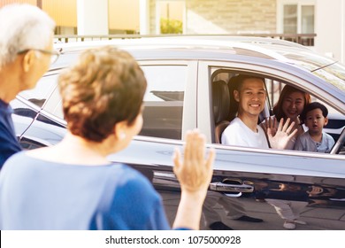 Asian Family Of Father, Mother And Son Waving Goodbye To Grandfather And Grandmother As They Take Off Their Journey