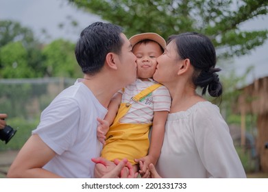 Asian Family Father Mother Son Hug Happy Together For A Holiday.