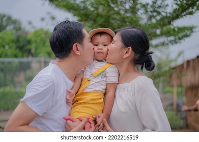 Asian Family Father Mother Son Hug Happy Together For A Holiday.