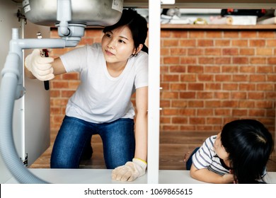 Asian Family Fixing Kitchen Sink