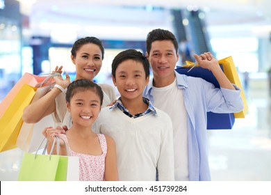 Asian Family Of Four With Many Shopping Bags