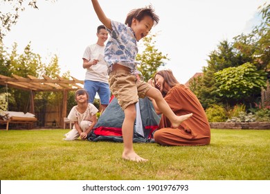 Asian Family In Garden At Home Putting Up Tent For Camping Trip Together - Powered by Shutterstock