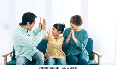 Asian family getting excited watching TV. Watching sports. - Powered by Shutterstock