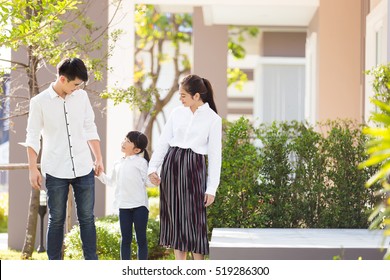 Asian Family Are Going Out Of The House , Parents And Children Were Walking Hand In Hand Together A Happy In Garden.