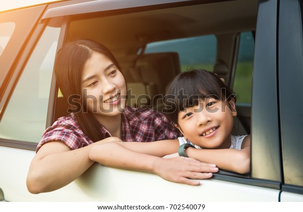 Asian family Happy in the car.Family vacation,\
car trip on summer, happy parents travel with kids and having fun,\
car insurance concept