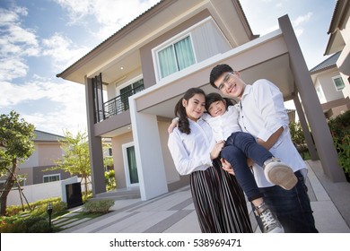 Asian family Happy Daughter pointing parents to look after her , with child over house background.