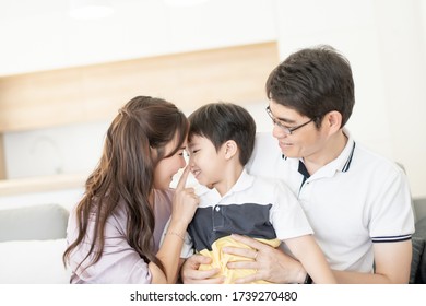 Asian Family Happy With Hug Together, Parent With Child Relax Lifestyle On Sofa Or Couch At House Concept.