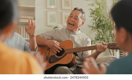 asian family Happy Multi Generation Family is Spending wonderful time at home Grandfather is Playing an Acoustic Guitar while Other Family Members are Singing and Enjoying in Together happy lifestyle - Powered by Shutterstock