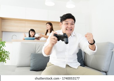 Asian Family Happy Resting Time In Long Weekend, Father Enjoy Play Console  Game Alone With Wife And Kids Learning Cooking In Kitchen Room Background