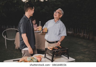 Asian Family Having A Barbecue Party At Home. Cooking Grilled Bbq For Dinner In Backyard. Lifetyle On Summer Holiday.