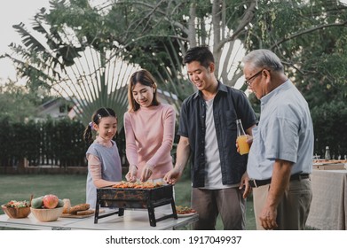 Asian Family Having A Barbecue Party At Home. Cooking Grilled Bbq For Dinner In Backyard. Lifestyle On Summer Holiday.