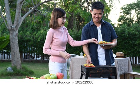 Asian family having a barbecue party at home. Cooking grilled bbq for dinner in backyard. Lifestyle on summer holiday.