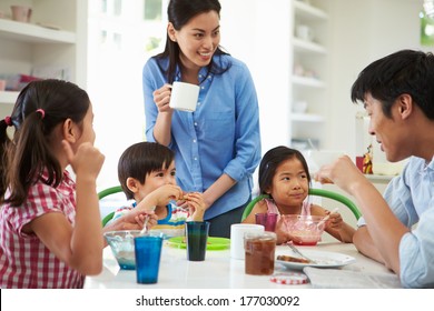 Asian Family Having Breakfast Together In Kitchen