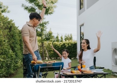 Asian Family Having Dinner In The Backyard At Home. Happy Family With Little Child Camping And Have Fun In House Backyard Outside. Barbecue Time, Family Activities Conccept.