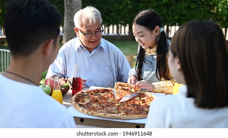 Asian family having pizza in garden at home. Parent with kid and grandfather lifestyle in backyard. - Powered by Shutterstock