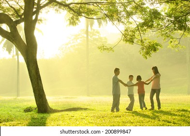 Asian Family Having Quality Time Playing Together In The Park