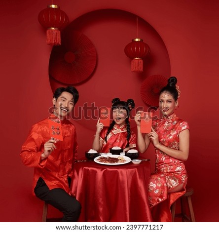 Asian family holding angpao,red packet monetary gift in the meal on celebration chinese new year isolated on red backdrop. Chinese text means Have a wish Blessing 5, good luck and much happiness, rich