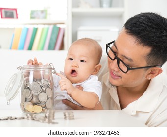 Asian Family Lifestyle At Home. Father And Child Saving Coins To Money Jar, Financial Planning Concept.