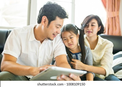 Asian Family Looking Tablet For Teach Children Home Work