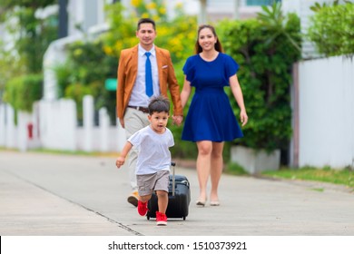 Asian Family With Luggage Leaving House For Vacation. Copy Space