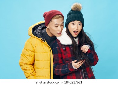 Asian Family Man And Woman In Warm Clothes With A Mobile Phone I