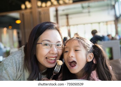 Asian Family Mother And Daughter Enjoy Eating Together In Restaurant